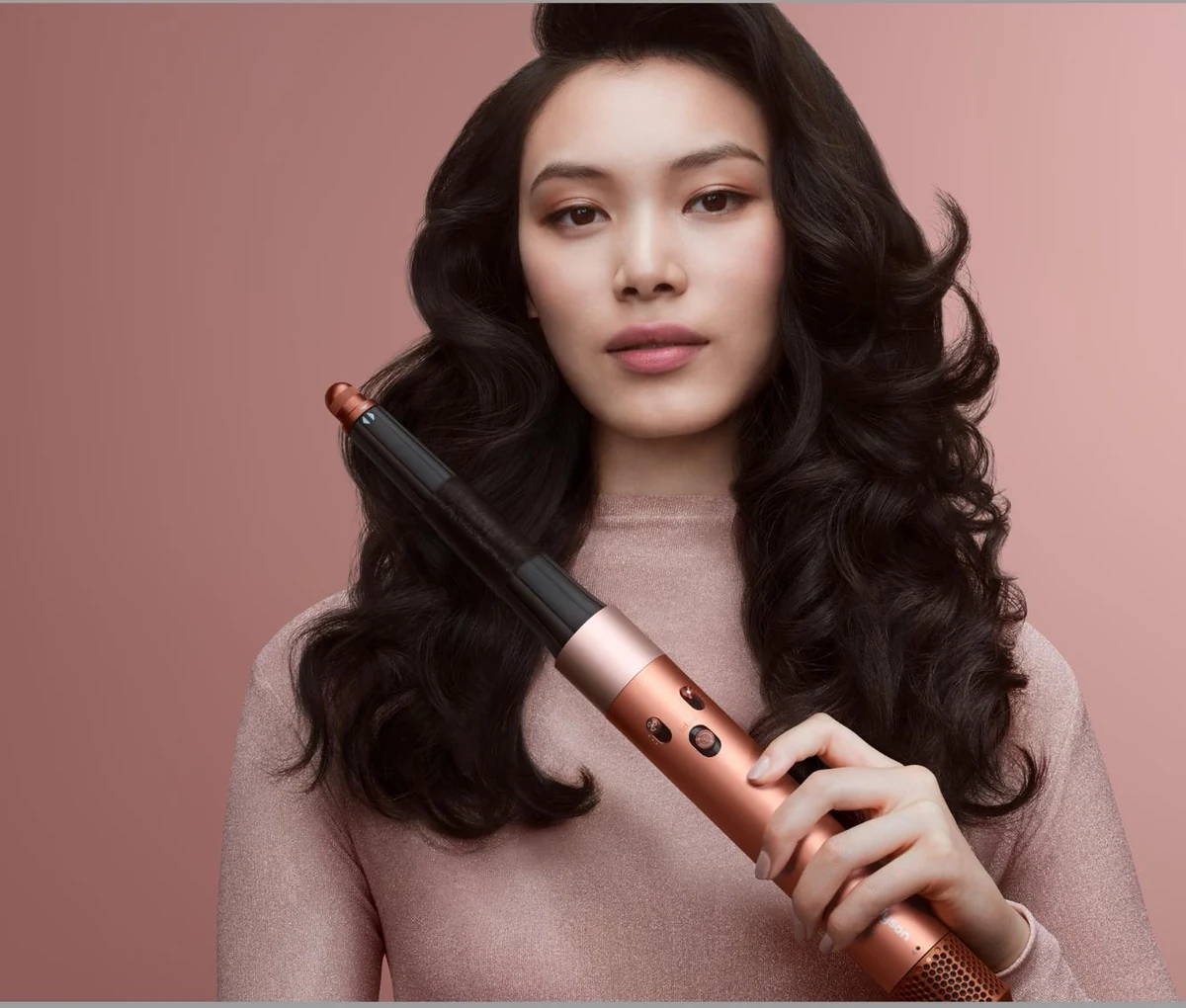 Модель держит мультистайлер Dyson Airwrap во время укладки